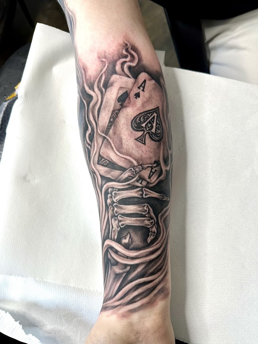 Unterarm-Tattoo: Pik-Ass mit Skeletthand